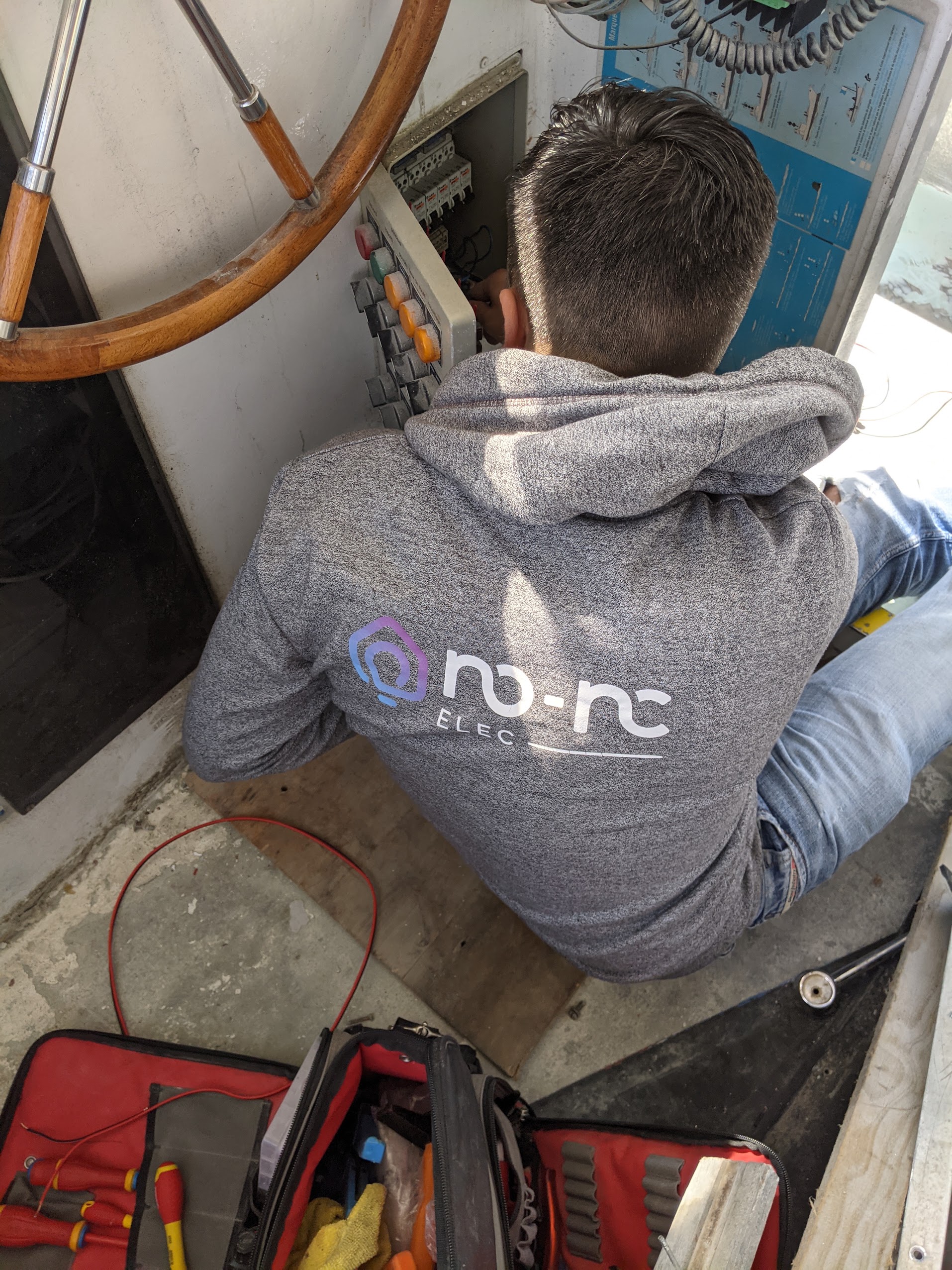 Technicien No-Nc ELEC réalisant une installation électrique marine à bord d'un bateau